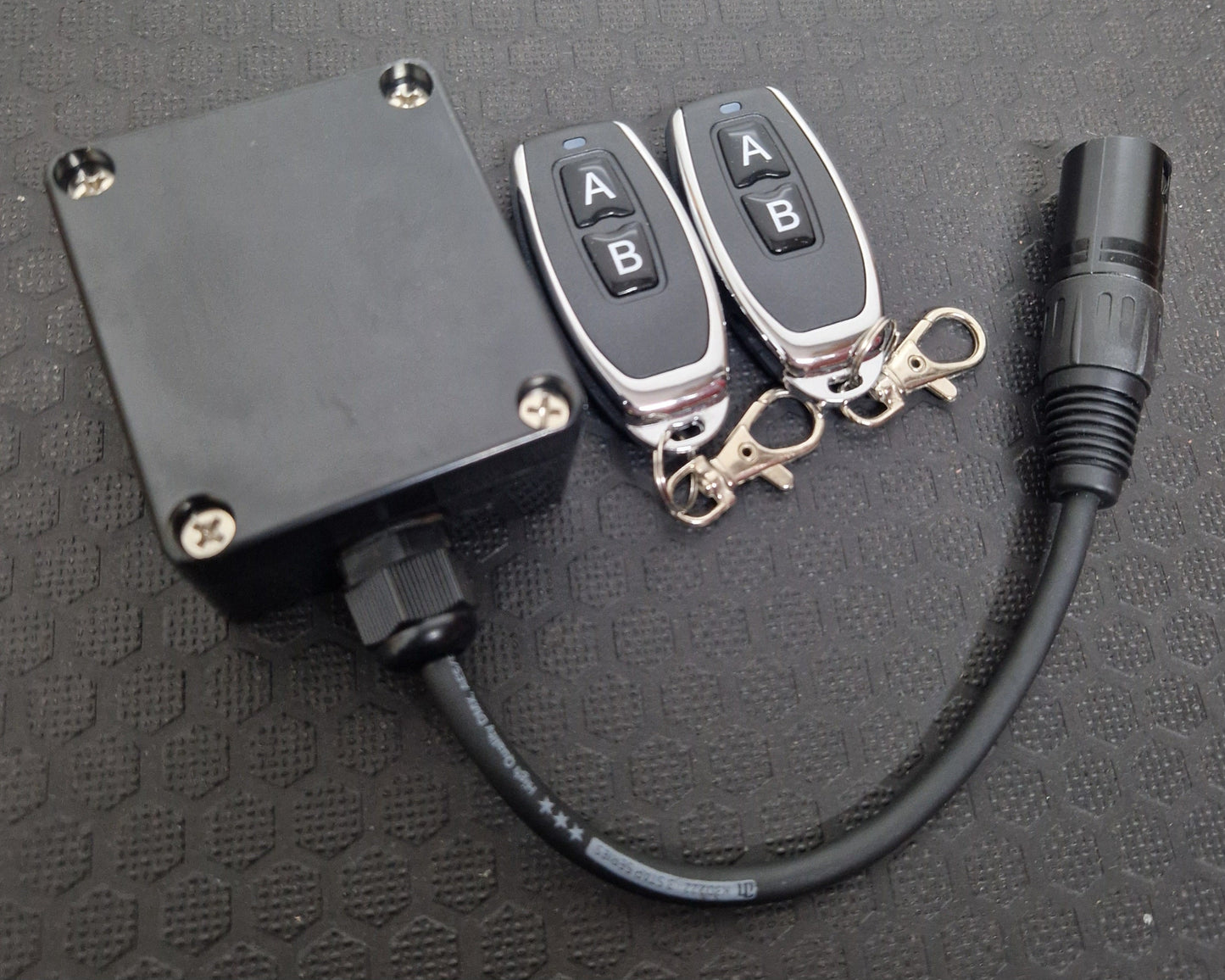 Trainer Range wireless remote control kit showing black plug-in box with cable and two keyfob remotes labeled A and B.