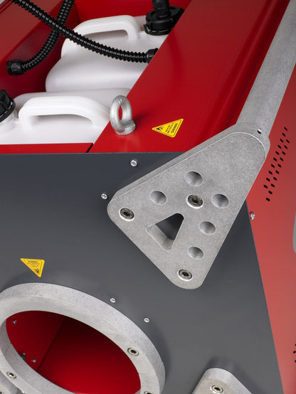 Close-up of MSS Trainer X-Stream smoke machine showing white fluid tanks, red casing, and silver protective frame with heavy-duty fittings.