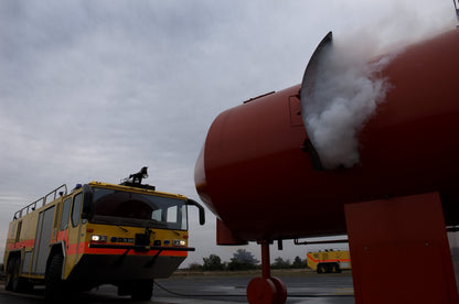 501 Trainer smoke machine in action during fire training exercise, producing realistic smoke near a fire truck for emergency response practice.
